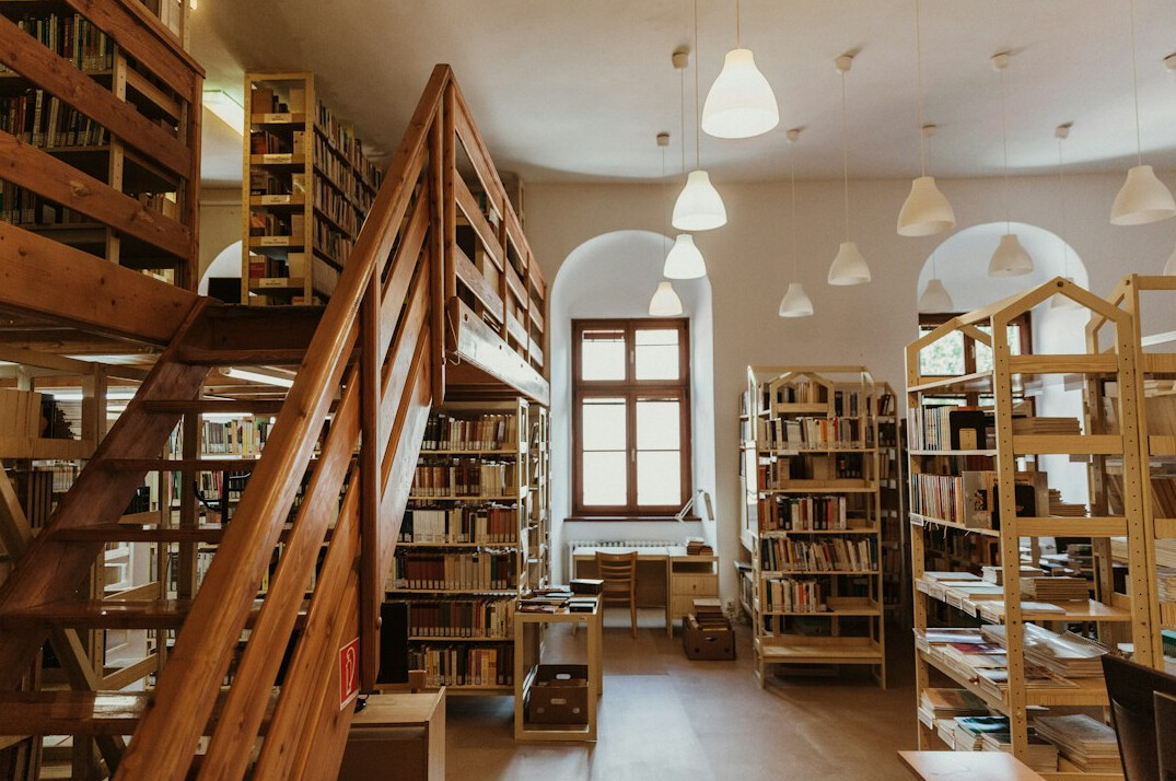 Atmospheric library with tall wooden bookshelves and warm light
